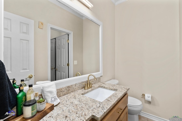 bathroom with vanity, toilet, and crown molding