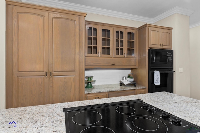 kitchen with backsplash, crown molding, black appliances, and light stone counters