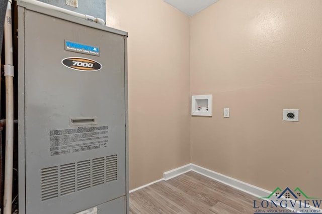 washroom featuring hookup for a washing machine, heating unit, wood finished floors, baseboards, and electric dryer hookup