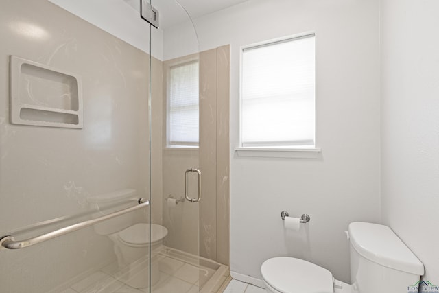 bathroom with tile patterned flooring, a shower with shower door, and toilet