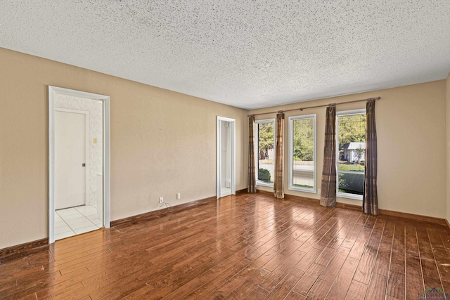 spare room featuring a textured ceiling and hardwood / wood-style flooring