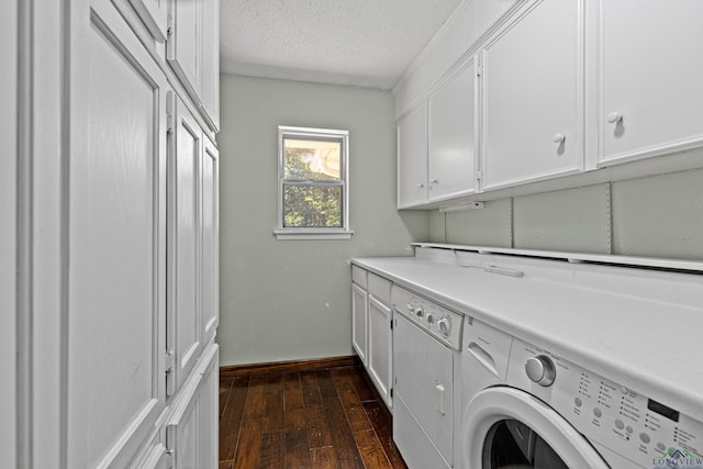 washroom featuring washing machine and clothes dryer, dark wood-type flooring, cabinets, and a textured ceiling