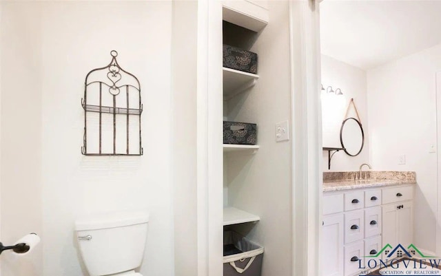 half bathroom featuring toilet and vanity