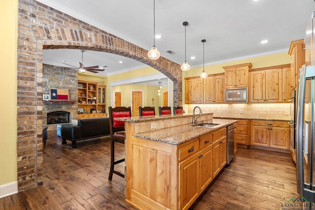 12265 Sable Ln, Whitehouse, TX 75791 - kitchen featuring a sink, stainless steel appliances, ceiling fan, arched walkways, and a breakfast bar