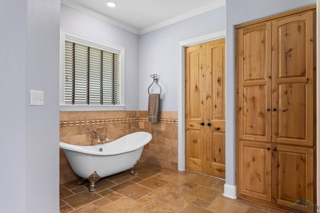 12265 Sable Ln, Whitehouse, TX 75791 - bathroom featuring tile walls, a freestanding tub, ornamental molding, stone tile flooring, and a wainscoted wall