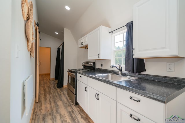 1203 Vesta Ave, Gladewater, TX 75647 - kitchen featuring electric range, a sink, lofted ceiling, wood finished floors, and white cabinets