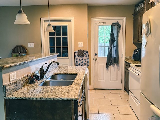 203 Reynolds St, Pittsburg, TX 75686 - kitchen featuring white appliances, hanging light fixtures, light stone counters, and light tile patterned floors