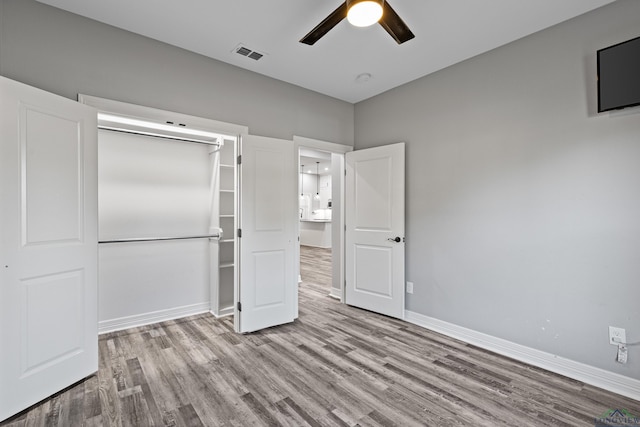 unfurnished bedroom with a closet, light hardwood / wood-style flooring, and ceiling fan