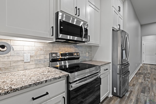 kitchen with decorative backsplash, appliances with stainless steel finishes, light stone countertops, white cabinets, and dark hardwood / wood-style floors