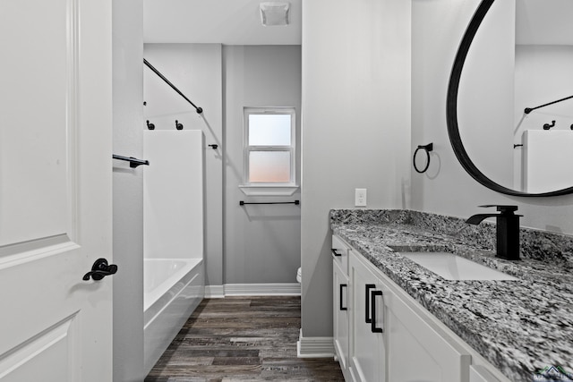 full bathroom featuring hardwood / wood-style floors, vanity, tub / shower combination, and toilet