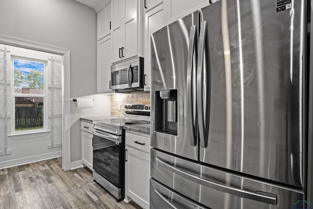 kitchen with white cabinetry, stainless steel appliances, tasteful backsplash, light hardwood / wood-style floors, and stone countertops