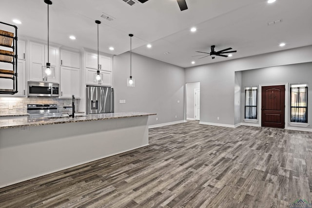 kitchen featuring white cabinetry, ceiling fan, light stone countertops, and appliances with stainless steel finishes