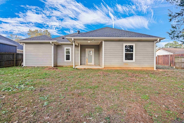 rear view of house with a lawn and a patio