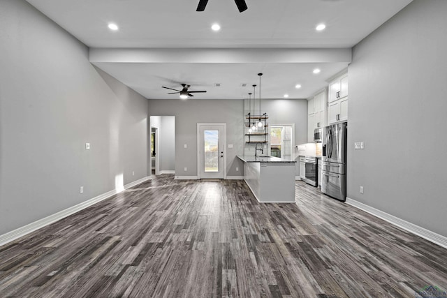 unfurnished living room with dark hardwood / wood-style floors, ceiling fan, and sink