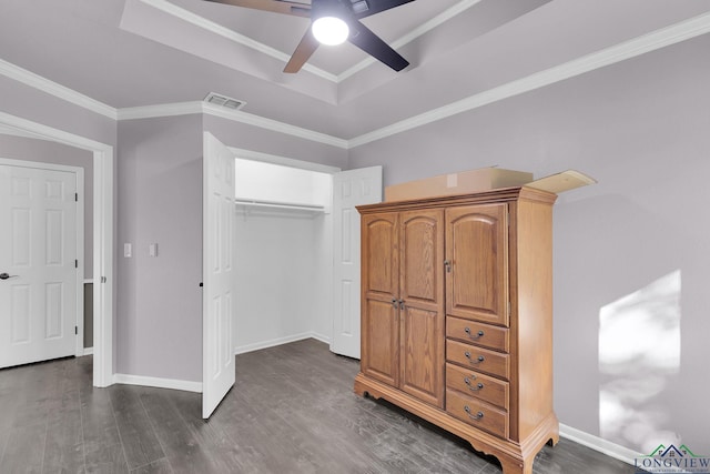 unfurnished bedroom with a raised ceiling, ceiling fan, dark hardwood / wood-style flooring, and ornamental molding