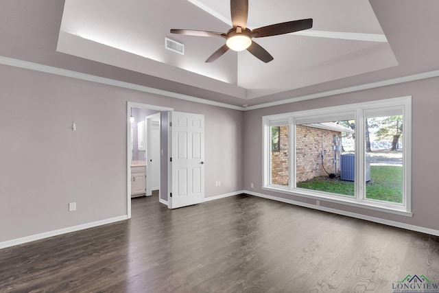 unfurnished room with a raised ceiling, ceiling fan, and dark wood-type flooring