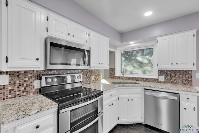 kitchen featuring backsplash, stainless steel appliances, white cabinetry, and sink