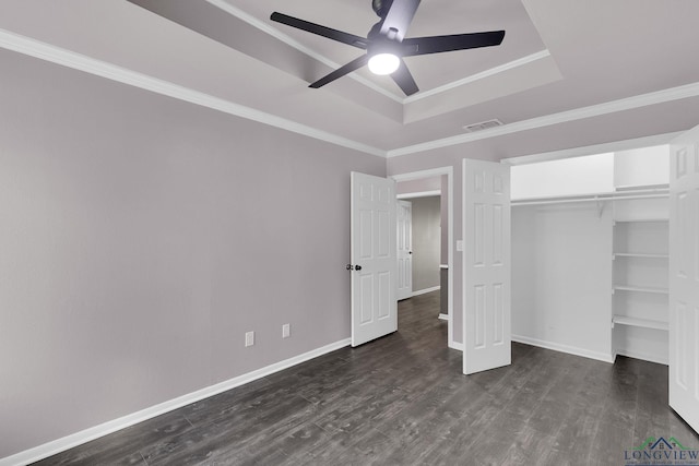 unfurnished bedroom featuring ceiling fan, dark hardwood / wood-style floors, ornamental molding, and a tray ceiling