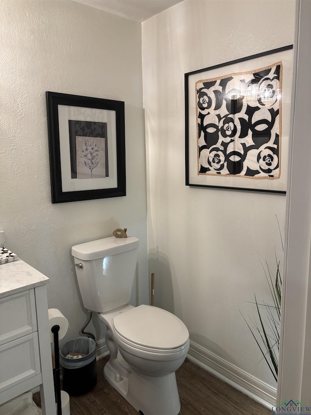 bathroom with wood-type flooring, vanity, and toilet