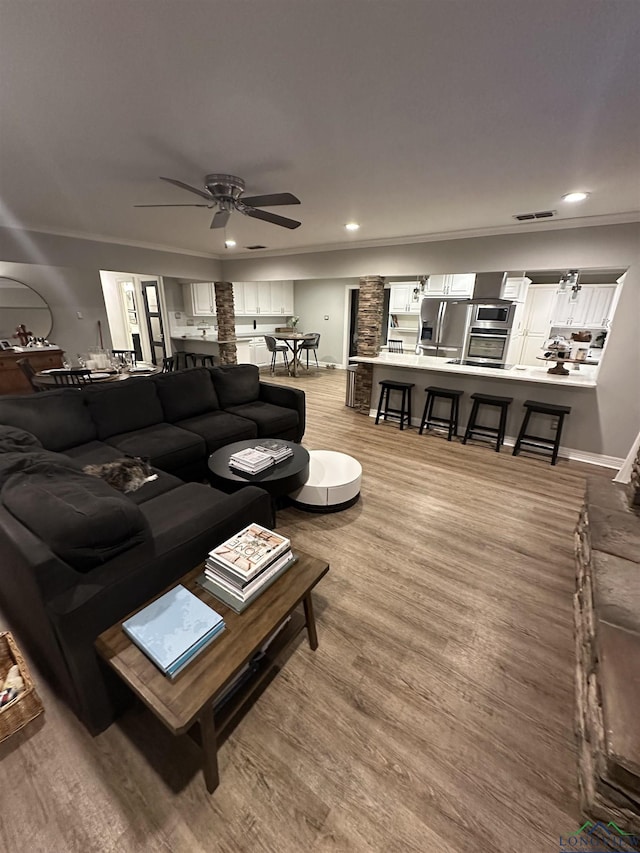 living room featuring crown molding and light hardwood / wood-style flooring