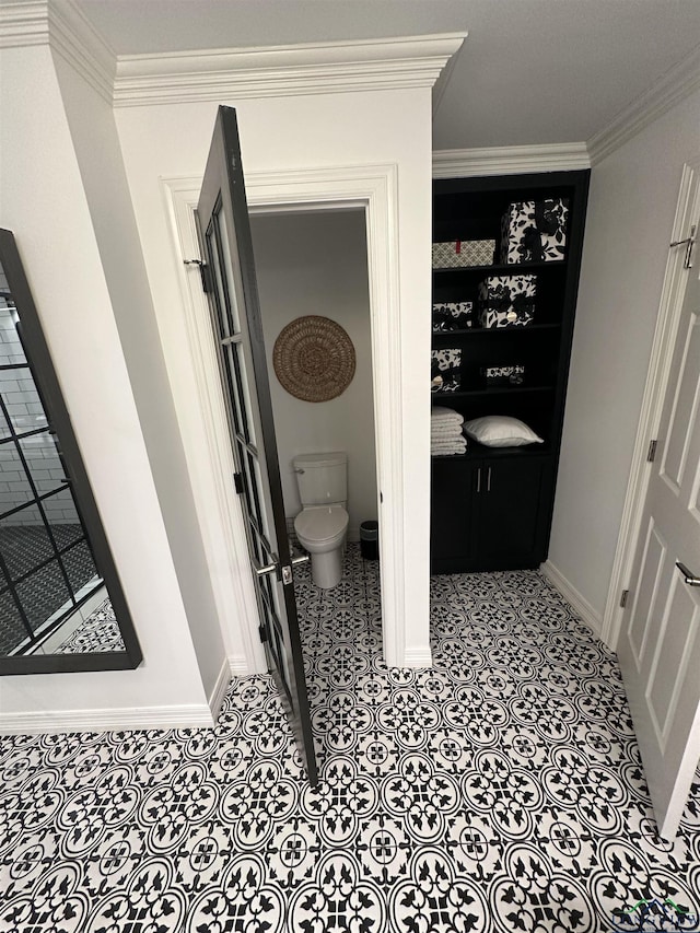 bathroom featuring ornamental molding and toilet