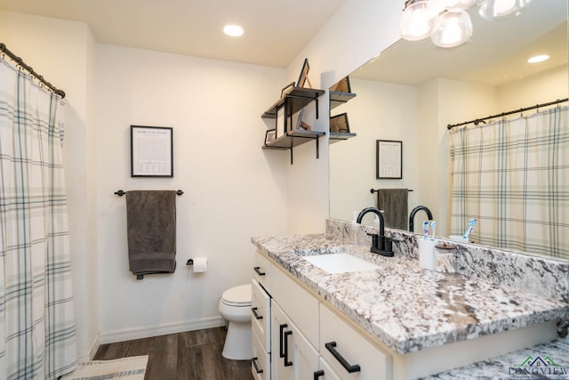 full bath with vanity, wood finished floors, baseboards, recessed lighting, and toilet