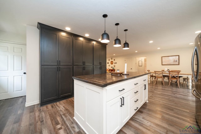 kitchen with dark wood finished floors, dark countertops, decorative light fixtures, and recessed lighting