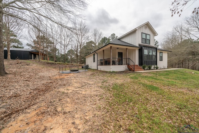 3381 Noonday Rd, Hallsville, TX 75650 - rear view of property featuring board and batten siding, a lawn, and a porch