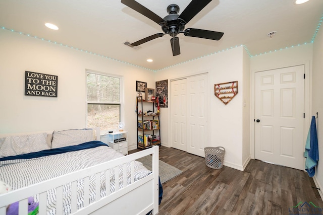 bedroom with dark wood finished floors, visible vents, recessed lighting, and a closet