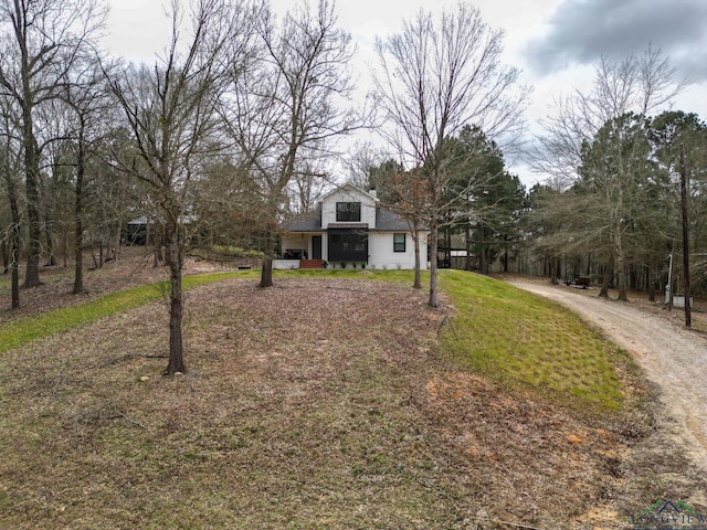 view of front of home featuring a front yard and dirt driveway