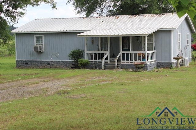 view of front of house with covered porch, metal roof, and a front yard