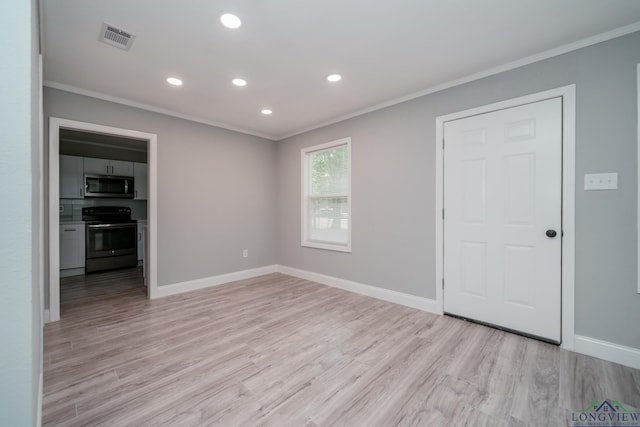 unfurnished room featuring light hardwood / wood-style flooring and crown molding