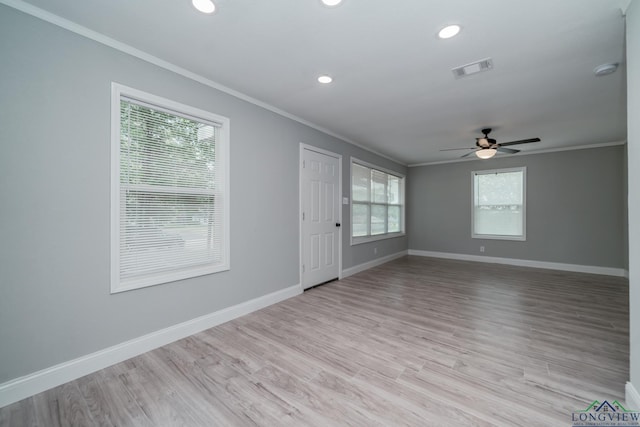 spare room with a wealth of natural light, light hardwood / wood-style flooring, and ornamental molding