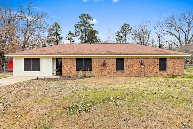 back of property with brick siding and a lawn