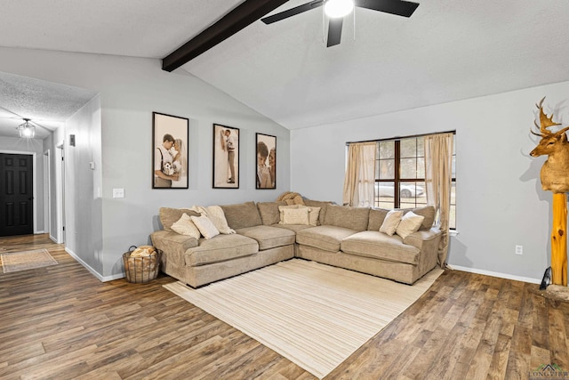 living area with lofted ceiling with beams, ceiling fan, a textured ceiling, wood finished floors, and baseboards