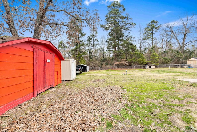 view of yard featuring an outbuilding, fence, and a shed