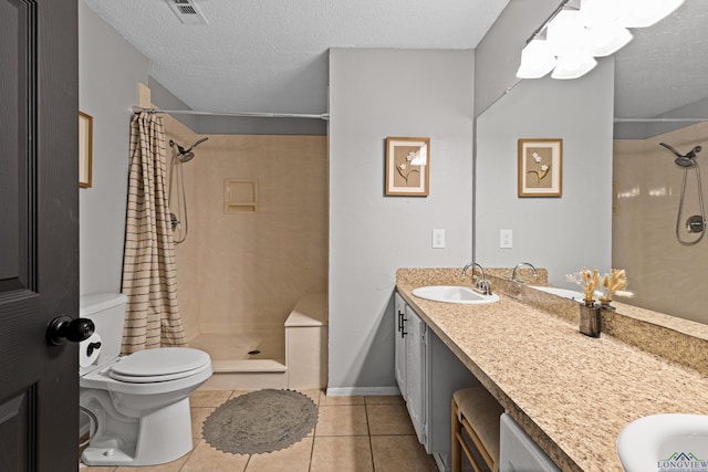 bathroom featuring a sink, a shower stall, a textured ceiling, and double vanity