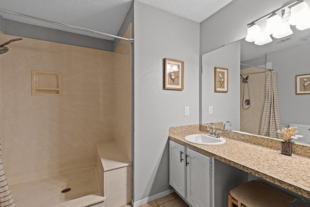 full bath with visible vents, a shower with shower curtain, a textured ceiling, vanity, and tile patterned flooring