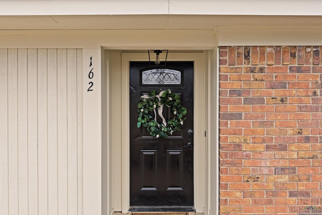 view of exterior entry with brick siding