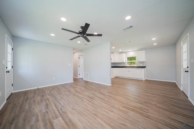18385 Fm 1716, Tatum, TX 75691 - unfurnished living room featuring recessed lighting, a sink, baseboards, and light wood-type flooring