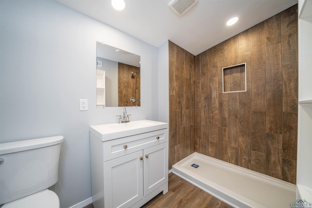 18385 Fm 1716, Tatum, TX 75691 - bathroom featuring toilet, vanity, tiled shower, wood finished floors, and recessed lighting