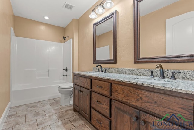 bathroom featuring double vanity, visible vents, toilet, and a sink