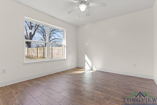 empty room featuring a ceiling fan, baseboards, and wood finish floors