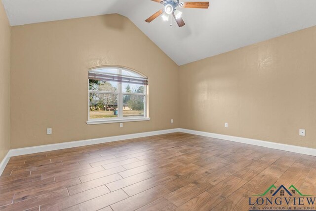 unfurnished room with a ceiling fan, vaulted ceiling, wood finished floors, and baseboards