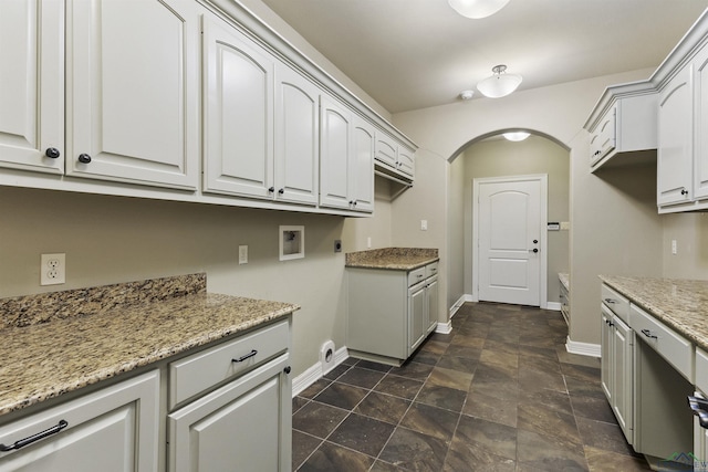 kitchen featuring white cabinets and light stone countertops