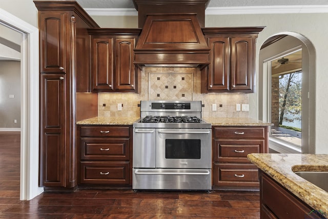 kitchen with custom exhaust hood, gas stove, light stone counters, and backsplash