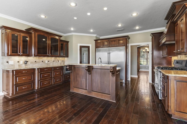 kitchen featuring dark brown cabinetry, crown molding, dark hardwood / wood-style floors, and premium appliances