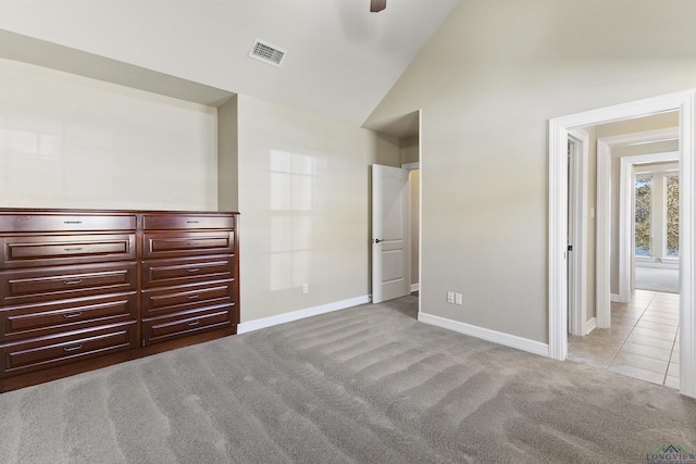 unfurnished bedroom with ceiling fan, light colored carpet, and lofted ceiling