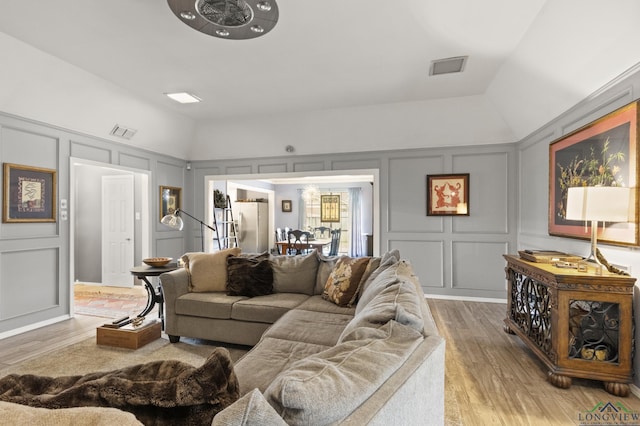 living room with hardwood / wood-style flooring and vaulted ceiling