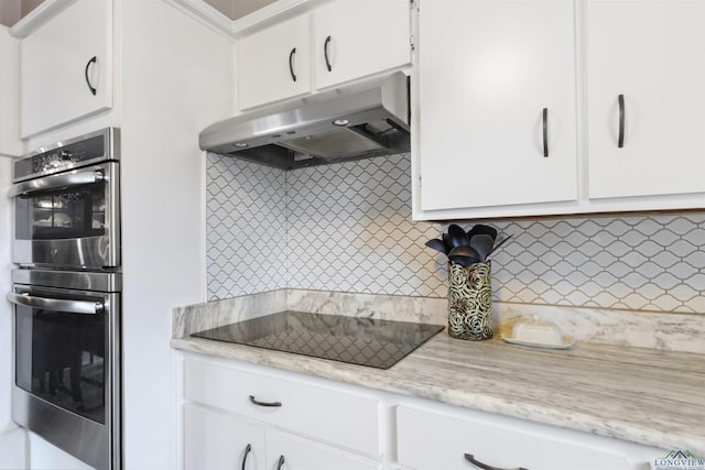 kitchen featuring black electric stovetop, white cabinets, tasteful backsplash, and stainless steel double oven